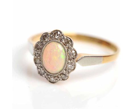 EARLY TWENTIETH CENTURY OPAL CLUSTER RING
set centrally with an oval cabochon cut opal, surrounded by brilliant cut diamonds,