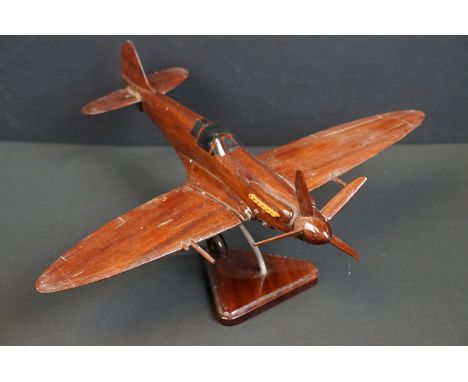 A carved wooden model of a RAF Spitfire on wooden plinth 