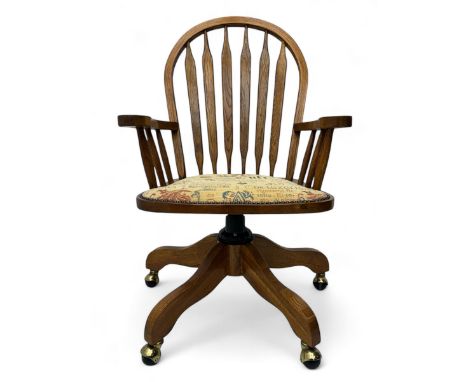 Late 20th century oak swivel office chair, curved hoop back incorporating six shaped vertical splats, shaped open arms extend