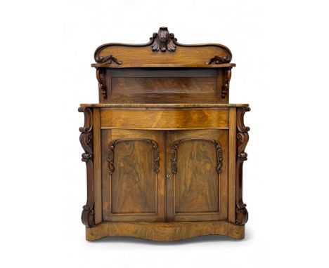Mid-19th century rosewood chiffonier, raised back with scroll and leaf carved shaped pediment, serpentine top over drawer and