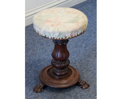 A William IV carved walnut adjustable piano stool - the stuff-over seat on a lappet carved baluster column to a dished base w