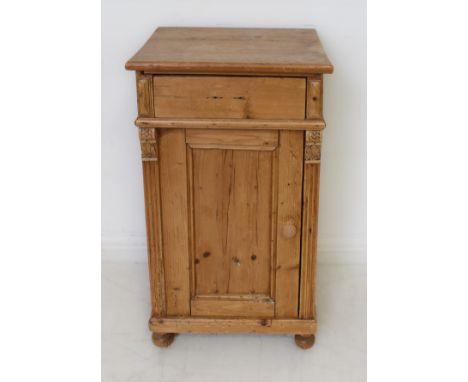 A Victorian pine bedside cabinet - single frieze drawer (lacks handle), on shell carved brackets over a panelled door enclosi