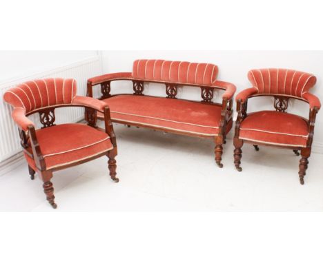 An Edwardian walnut three-piece parlour suite - comprising a two-seater sofa and a pair of tub armchairs, the curved backs wi