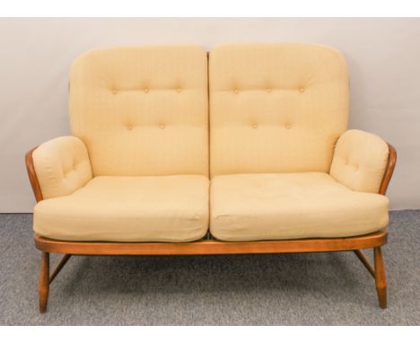 An Ercol Windsor beech and elm two-seater sofa - Jubilee model, no.766, with original pale gold upholstered cushions, maker's