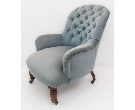 A Victorian button-back tub armchair - upholstered in blue velour, on turned mahogany front legs with pottery castors. (WH 68