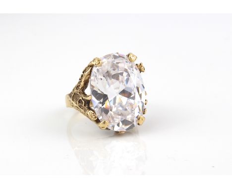 A 9ct gold ring set with a large rock crystal - the oval cut rock crystal, approx. 21.5 x 16mm, in a foliate and bark effect 