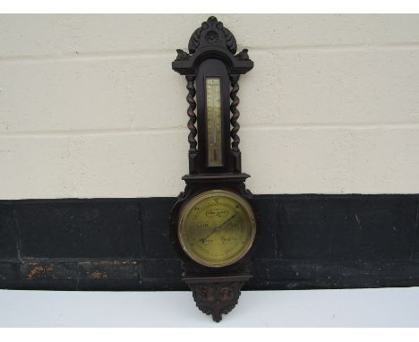 An early 20th Century English barometer with barley twist supports and brass face, 88cm tall
