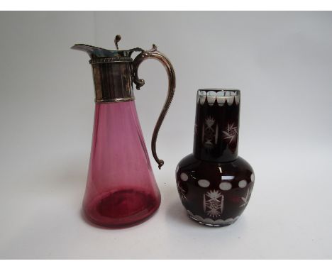 A Cranberry glass claret jug with plated neck and handle and ruby glass water jug with cup 