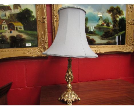 An ornate brass table lamp with shade