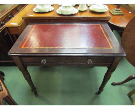 A mid Victorian oak writing desk the tooled leather inset over a single frieze drawer with working key on turned and tapering