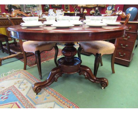 Circa 1840 a circular tilt top table on carved and turned column over scroll foot carved tripod legs and white ceramic castor