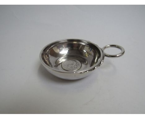 A white metal ring handled wine taster inset with two franc coin, possibly 19th Century, 8cm diameter, 89g 