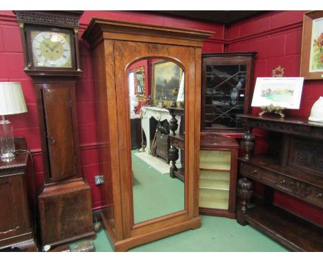 A mid Victorian walnut wardrobe, the stepped cornice over large arched mirrored door opening to reveal hanging space and base