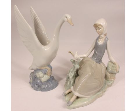 LLADRO FIGURINE - a seated girl with a dove, 17cms tall, also a Nao swan, 18.5cms tall