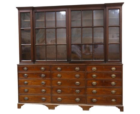 A 19th century mahogany library bookcase, with 4 lattice-glazed cabinets above, and 15 drawers below with original embossed b