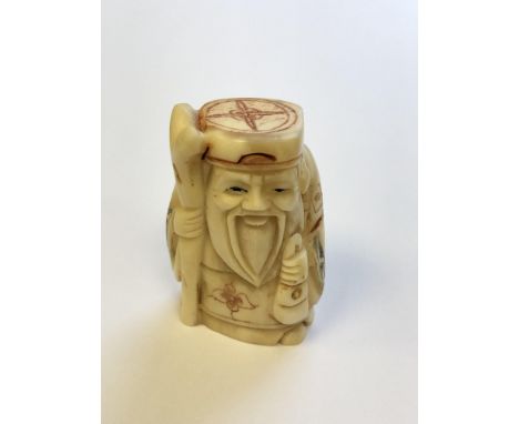 A Japanese carved bone netsuke - village elder carrying a staff 