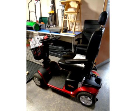 A Pride mobility cart with key and charger, and instruction manual 
