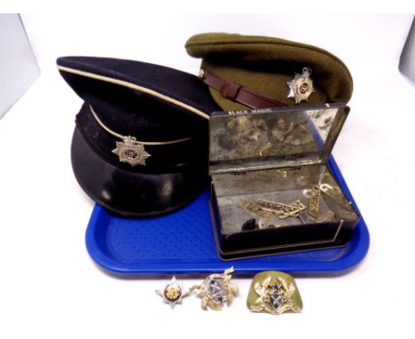 A cap bearing a Royal Corps of Transport badge together with a further cap bearing an Army Service badge, a Black Magic tin c