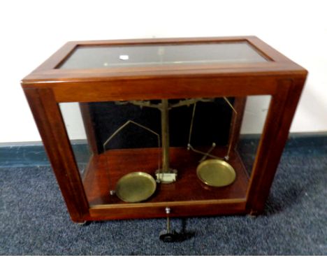 An antique set of brass chemist's scales in a display case 