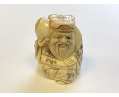 A Japanese carved bone netsuke - village elder carrying fruit on his shoulder 