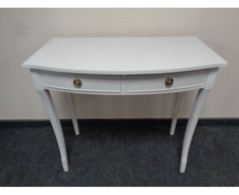 A serpentine fronted two drawer console table on raised legs 