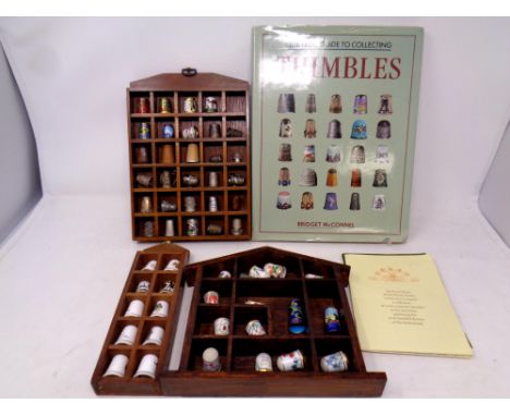 A large wooden thimble stand together with three further thimble stands containing a large quantity of enamel bone china and 