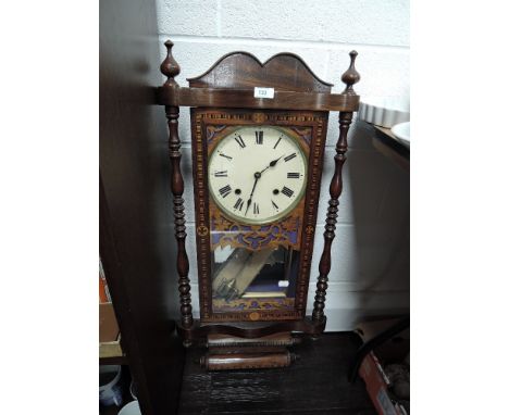 An early 20th century American style wall clock having carved and inlaid detailing.