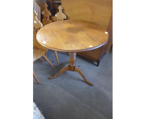 An oak circular tripod table 