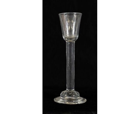 A Cordial Glass, circa 1750, the rounded funnel bowl on a tall plain stem and domed foot, 17.7cm highFor a related example se