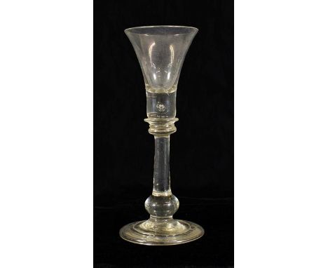 A Cordial Glass, circa 1720, the trumpet bowl with air tear to solid base, on annular knops, plain stem, basal knop and folde