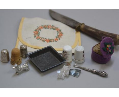 A horn handled knife, an embroidered 1930s handkerchief case, two china thimbles, two silver thimbles, a bakelite thimble, a 