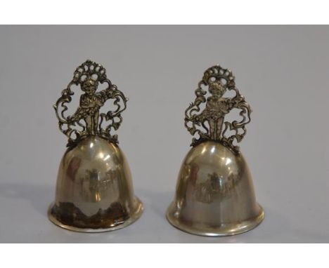 A pair of Kraftalpacca white metal pierced figure bells with engraved intials A and M (missing clappers) (h.8cm), £20-40