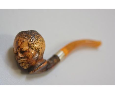 A late 19thc Meerscham blackamoor carved figure pipe with amber mouthpiece and silver mount (l. 13cm), £30-50