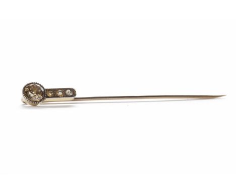 DIAMOND STICK PINset with an old round brilliant cut diamond with cognac tones of approximately 0.40 carats and three further