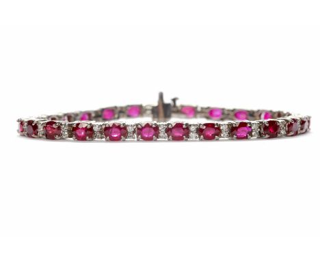 WHITE GOLD RUBY AND DIAMOND TENNIS BRACELET set with twenty six oval cut sapphires totalling approximately 10.80 carats, with