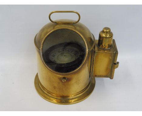 An unusual polished brass gimble compass with side paraffin burner to illuminate the dial, the case stamped: B3020.