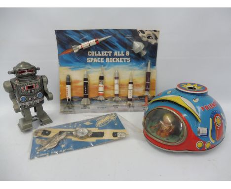 A Japanese tinplate UFO in excellent condition, plus a Space Navigator wrist mounted compass and a set of Space Rockets, on o