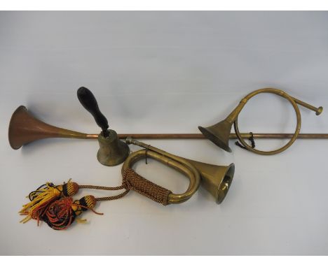 A military brass bugle with rope grip and tassels, plus a copper hunting horn, one other and a school bell. 