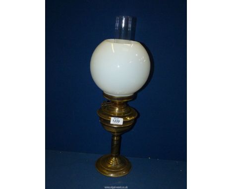 A brass Oil Lamp with brass reservoir and white glass shade, 21'' tall.