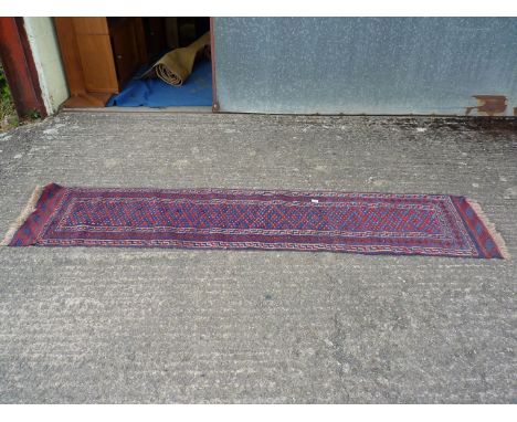 A geometric patterned Runner in blue and red, 103'' x 22''.