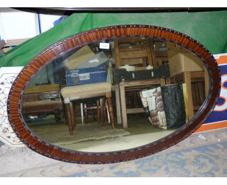 A large oval Mahogany framed Wall Mirror with small carved detail to the inner and outer edges of the frame, 38'' high x 25''
