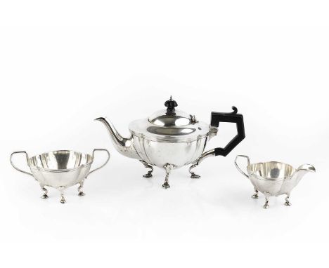 A George V silver three piece bachelor's tea service, of quatrefoil outline and with reeded borders, on shaped pad feet, the 