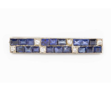 A sapphire and diamond bar brooch, designed as two rows of rectangular step-cut sapphires in channel settings, spaced by indi