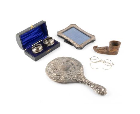 A small collection of silver, to include an embossed hand mirror, Chester 1905, a pair of napkin rings, cased, a photo frame,