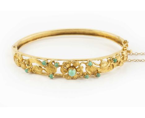 A turquoise set bangle, of hinged oval form, the pierced and tapered frontispiece of textured flowerheads and foliage highlig