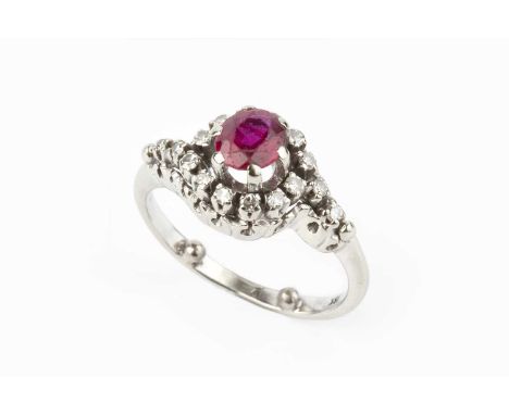 A ruby and diamond cluster ring, of crossover design, the oval mixed-cut ruby claw set within a border of single-cut diamonds