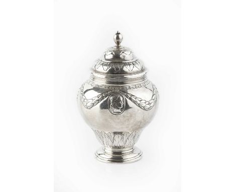 A late Victorian silver tea caddy and cover, of baluster urn form, embossed with laurel swags and paterae, by Pairpoint Bros,