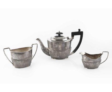 A late Victorian silver bachelor's teapot, and matching milk jug, with half lobed decoration, the teapot with ebonised handle