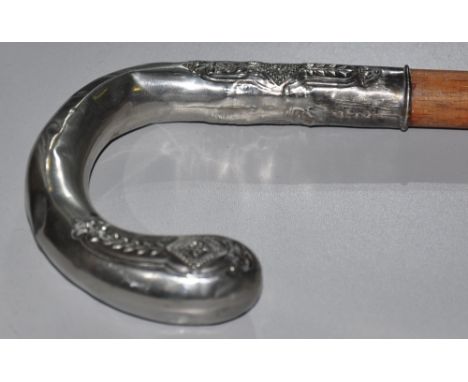 An early 20th Continental white metal handled walking stick with embossed decoration