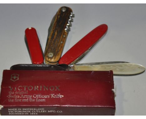 A Victorinox Swiss Army knife, boxed, together with two smaller examples by the same maker, a mother of pearl mounted silver 